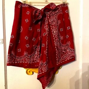 Red bandanna wrap style cover-up or skirt ties in front comes to a draping point